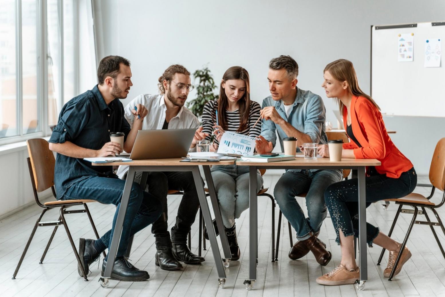 Teammitglieder diskutieren gemeinsam vor einem Whiteboard
